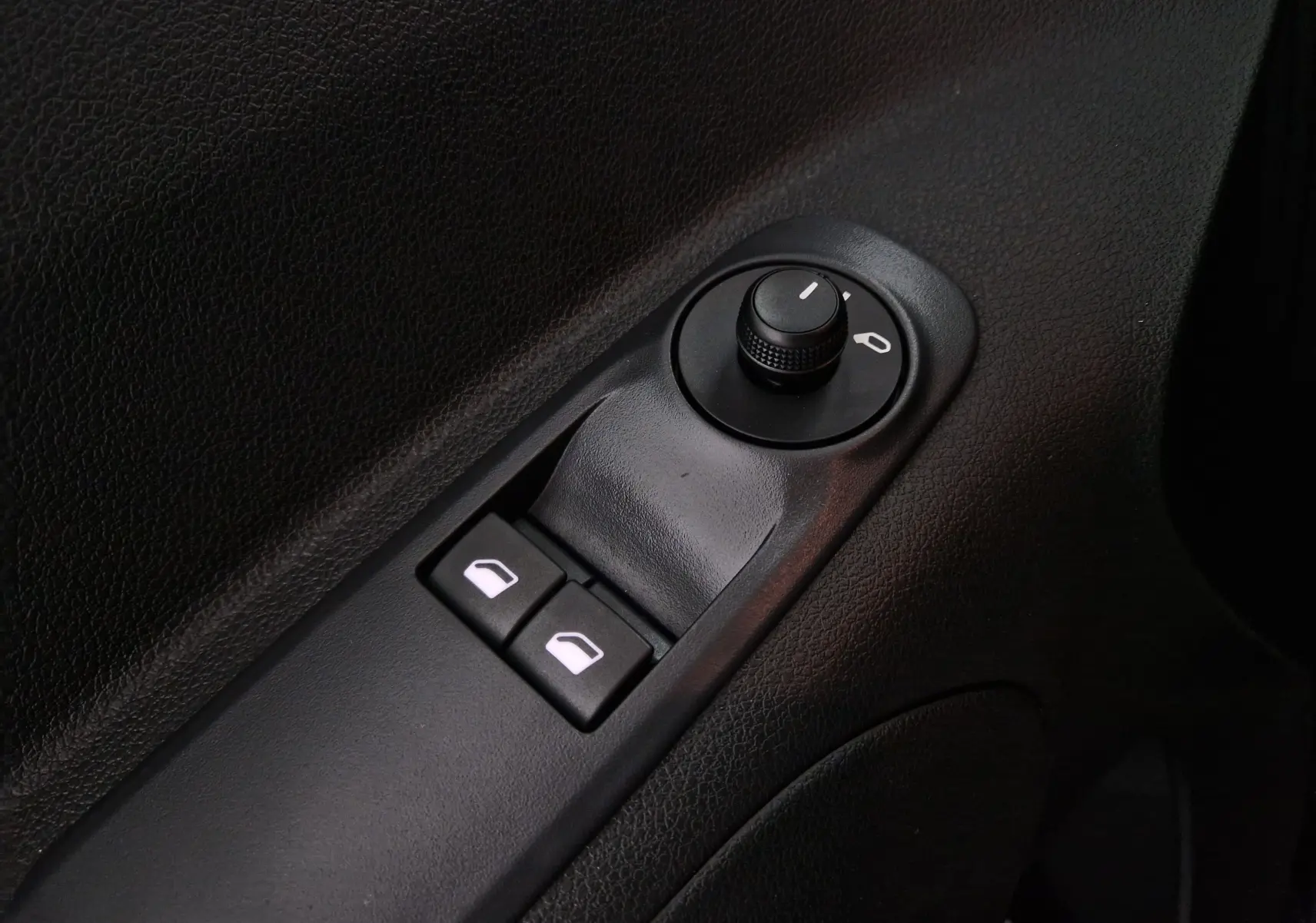 Gros plan sur les commandes de réglage des rétroviseurs et des vitres côté conducteur de l'Opel Combo Life vert Sirkka 2025.
