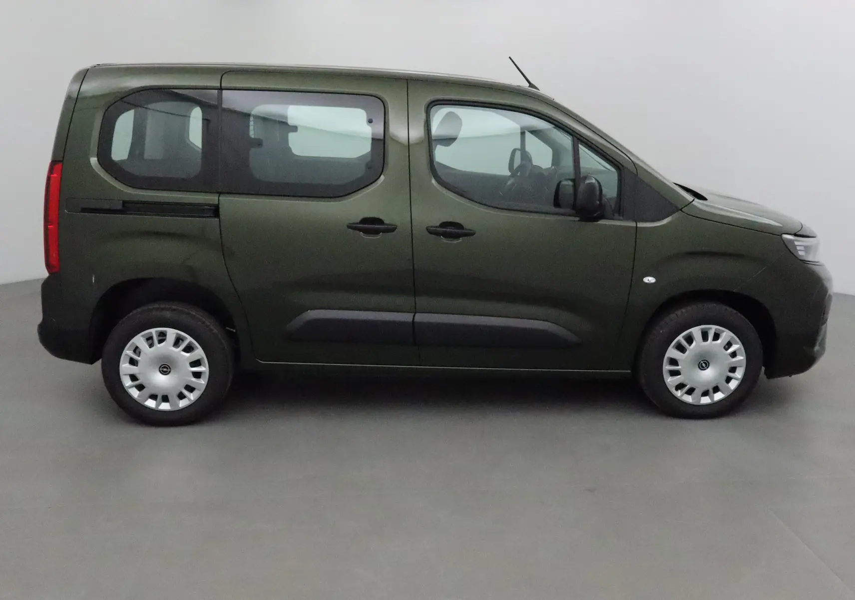 Profil côté gauche d'un Opel Combo Life vert Sirkka avec trois portes latérales et fenêtres teintées.