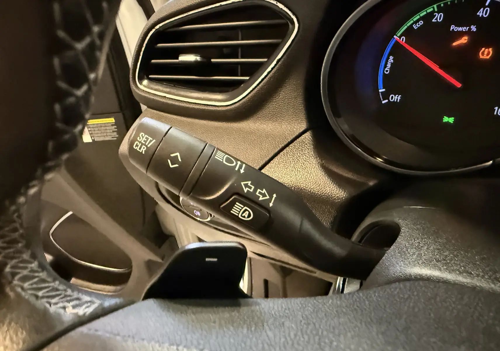 Gros plan sur la manette de clignotants et le compteur digital du tableau de bord de l’Opel Grandland X blanc hybride.