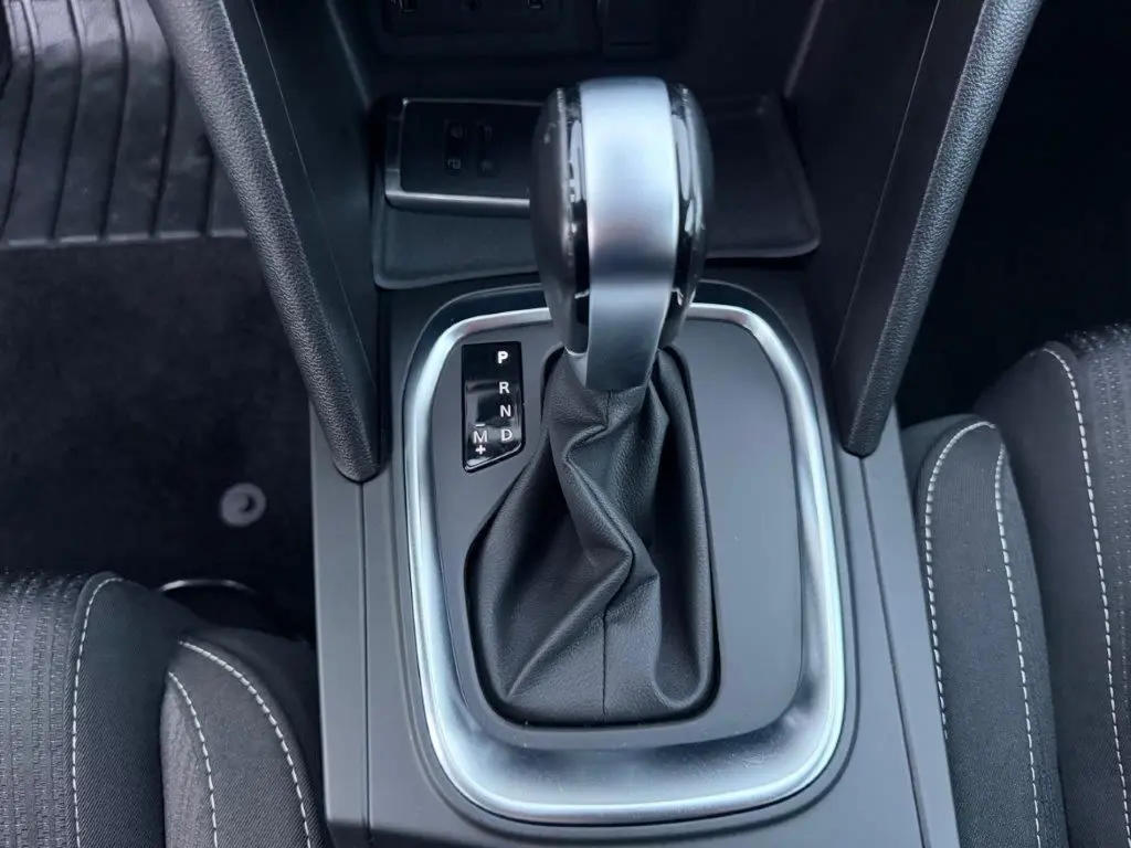 Vue rapprochée de la commande de boîte automatique de la Renault Mégane Business, avec cuir noir et coutures blanches.