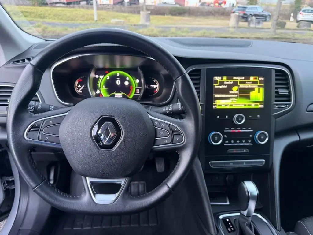 Vue intérieure centrée sur le volant noir de la Renault Mégane Business avec tableau de bord numérique et écran tactile.