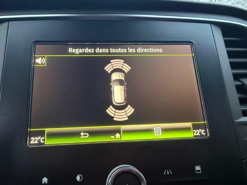 Écran central de la Renault Mégane Business affichant l'alerte de surveillance des angles morts et la température à 22°C.