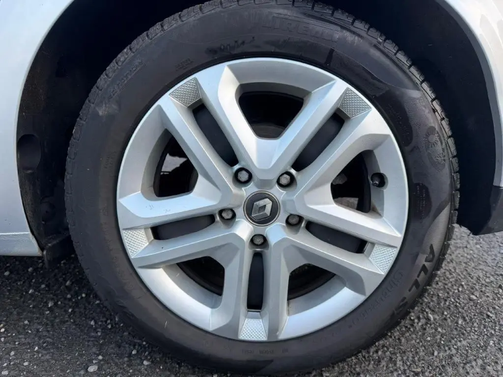 Gros plan sur la jante alliage gris alu de la Renault Mégane Business, mettant en valeur le logo central et le pneu Pirelli.