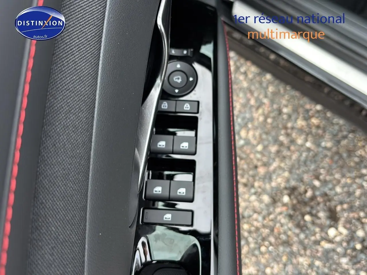 Détail de la porte côté conducteur du Hyundai Tucson noir 2026, avec commandes de vitres et surpiqûres rouges.