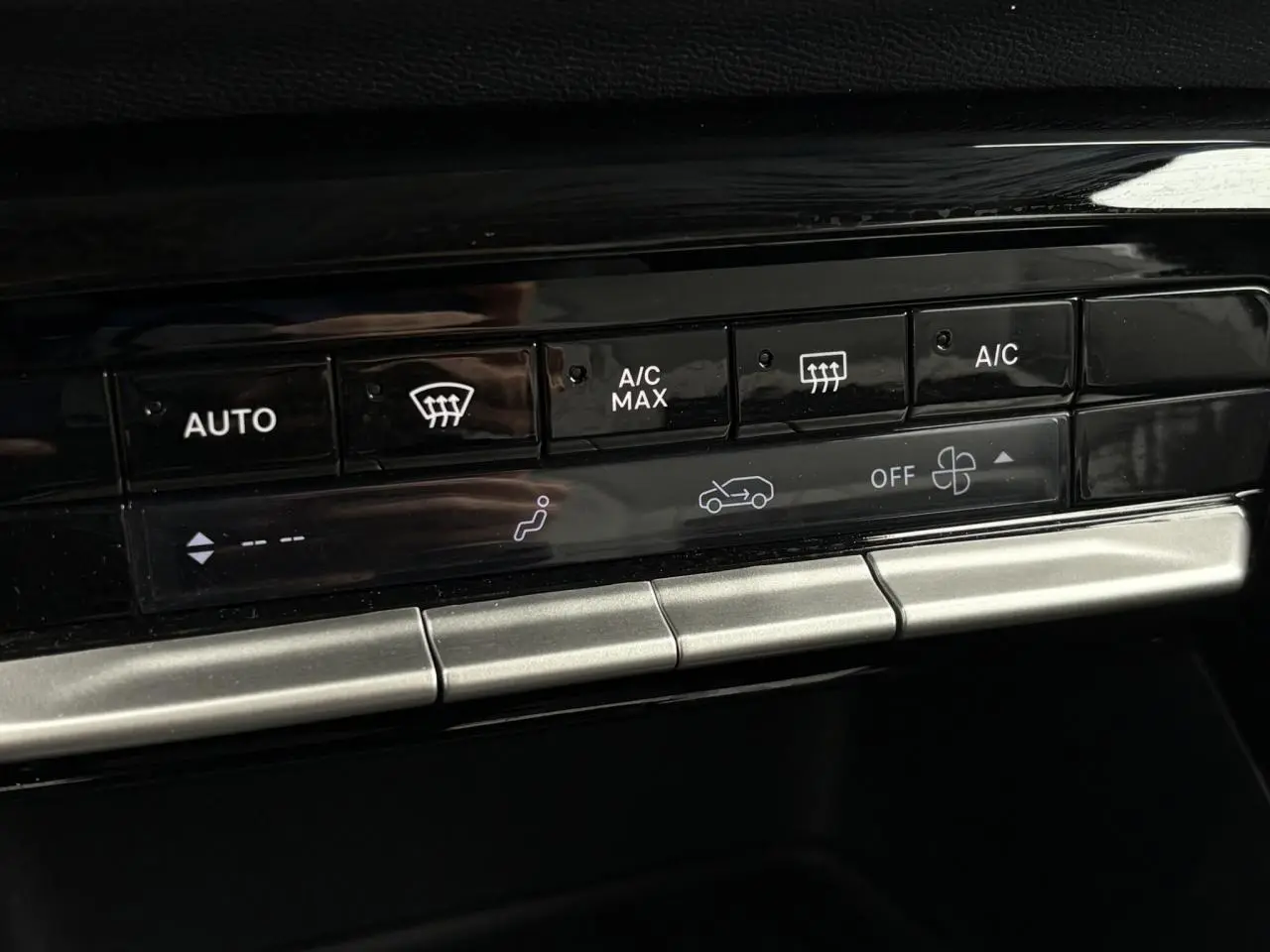 Gros plan sur les commandes de climatisation automatique du tableau de bord du Citroën C3 Turbo 100 Max noir Perla.