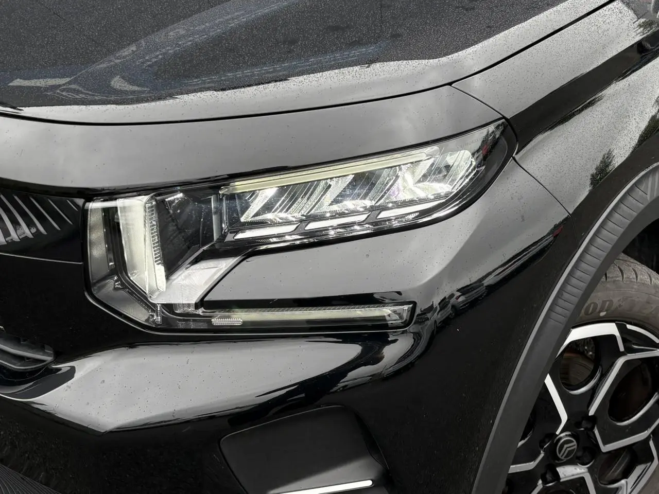 Gros plan sur le phare avant droit et la roue alliage 17" de la Citroën C3 Turbo 100 Max noir Perla.