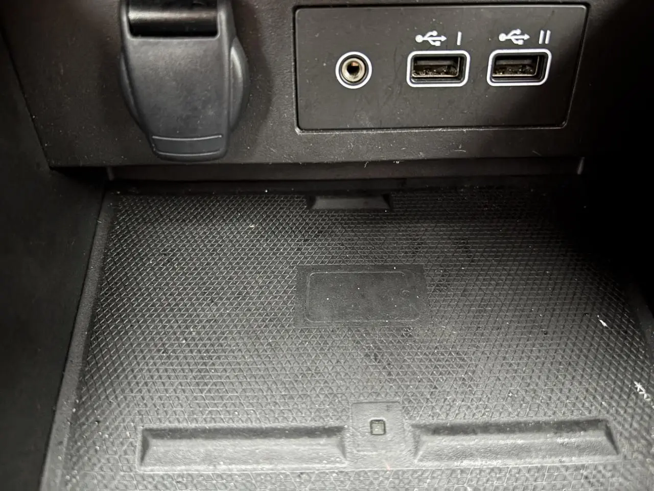 Gros plan sur la console centrale noire avec ports USB et prise jack dans une Renault Clio rouge flamme 2025.