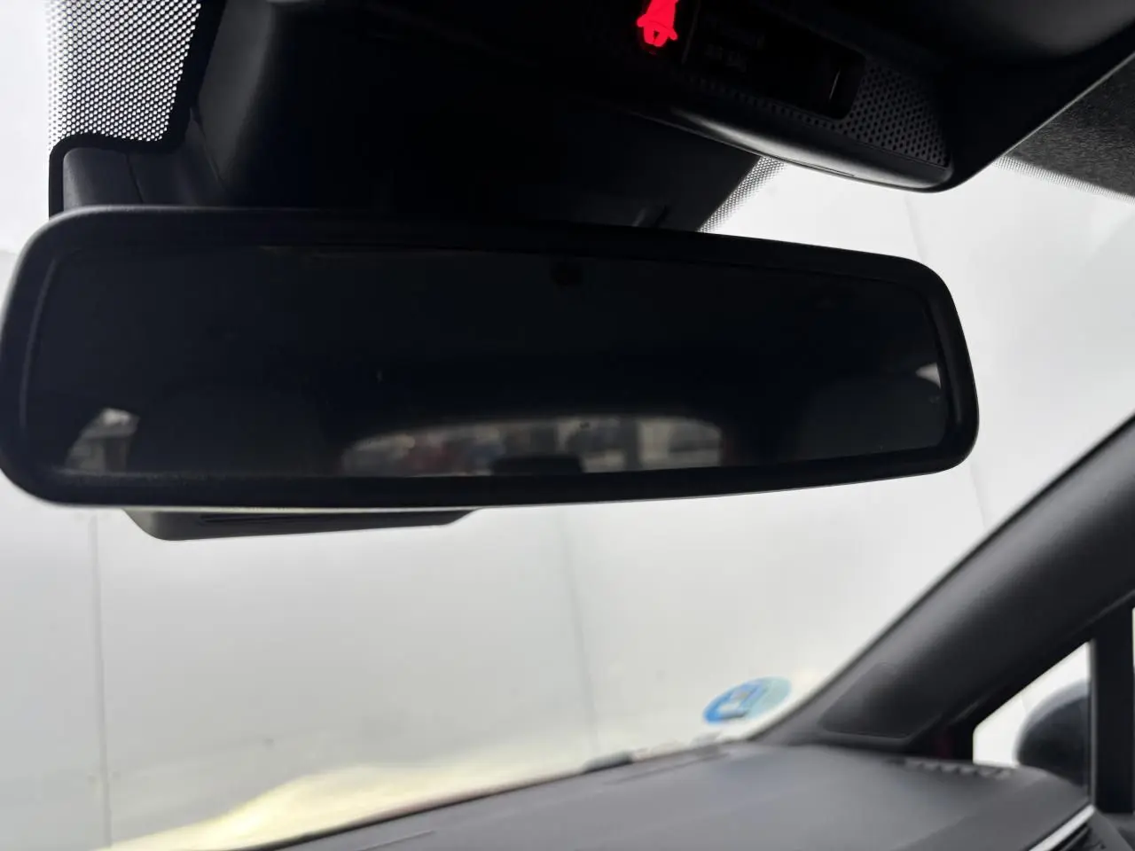 Rétroviseur intérieur noir de Renault Clio V rouge flamme, vue depuis le siège conducteur vers l'avant.