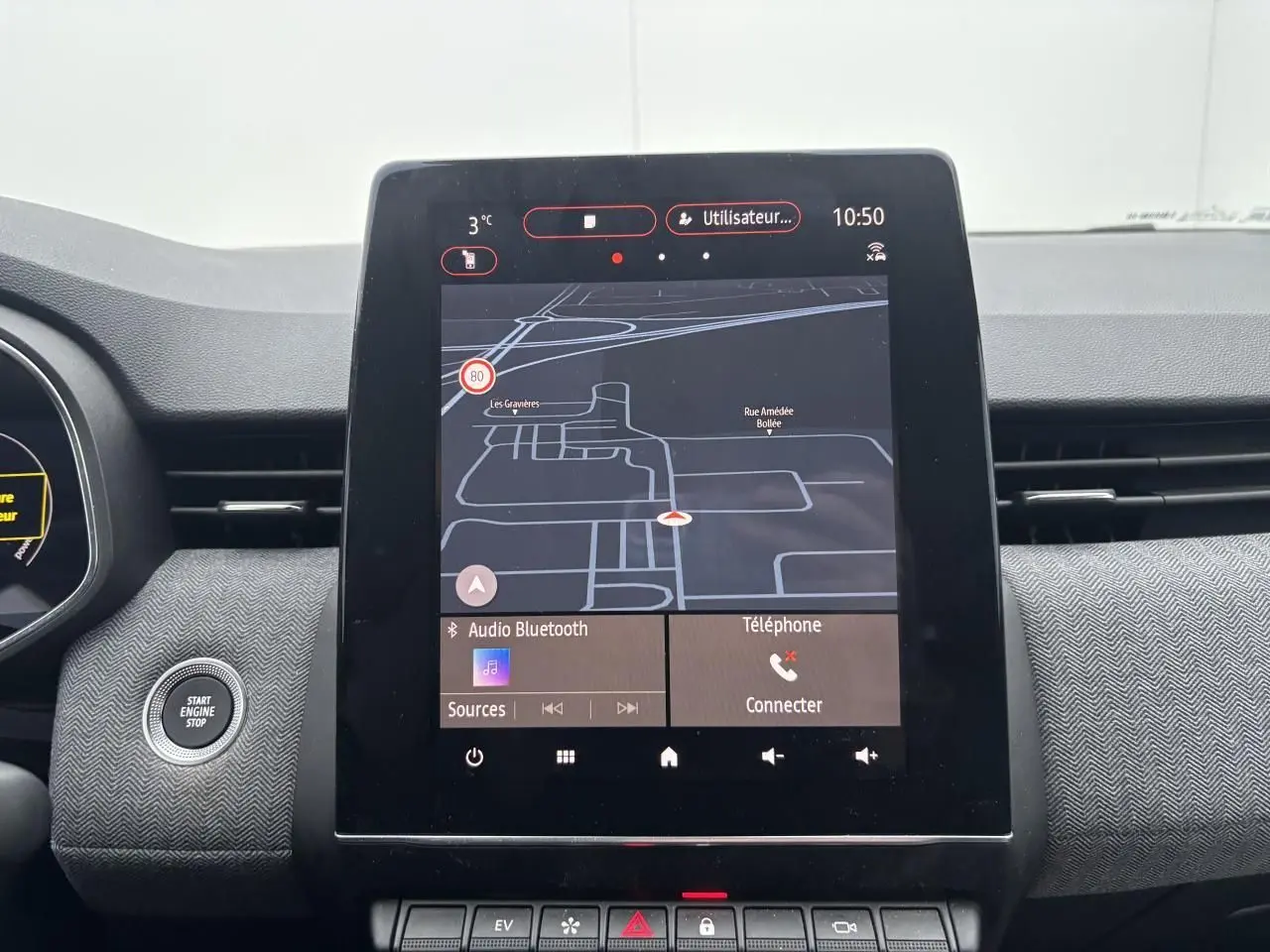 Vue rapprochée de l'écran tactile central du tableau de bord de la Renault Clio V rouge flamme, affichant la navigation GPS.