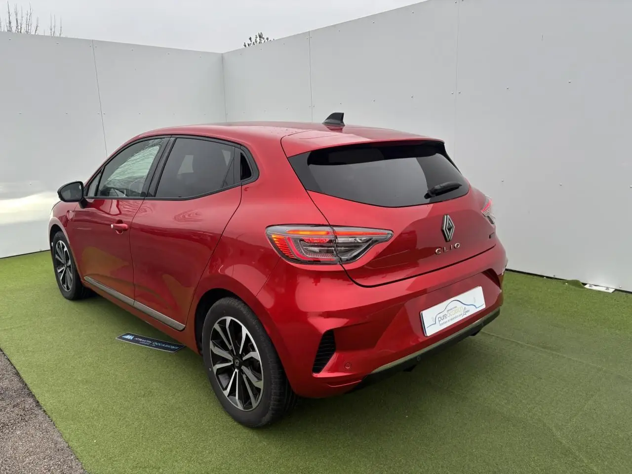 Vue 3/4 arrière droite de la Renault Clio V rouge flamme métal avec feux LED et jantes alliage 16 pouces.