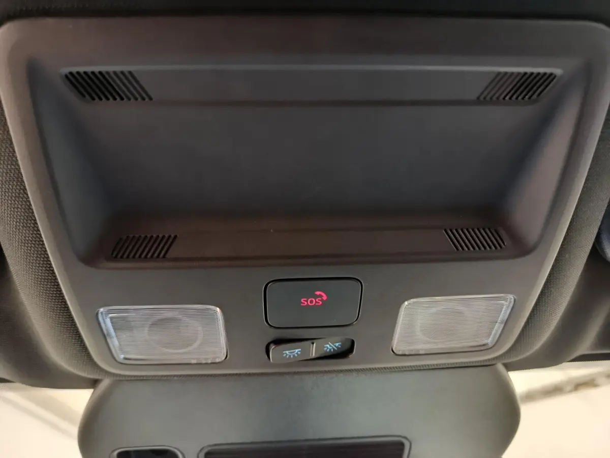 Gros plan sur le plafonnier intérieur noir du Ford Kuga 2024 avec bouton SOS et éclairages intégrés.