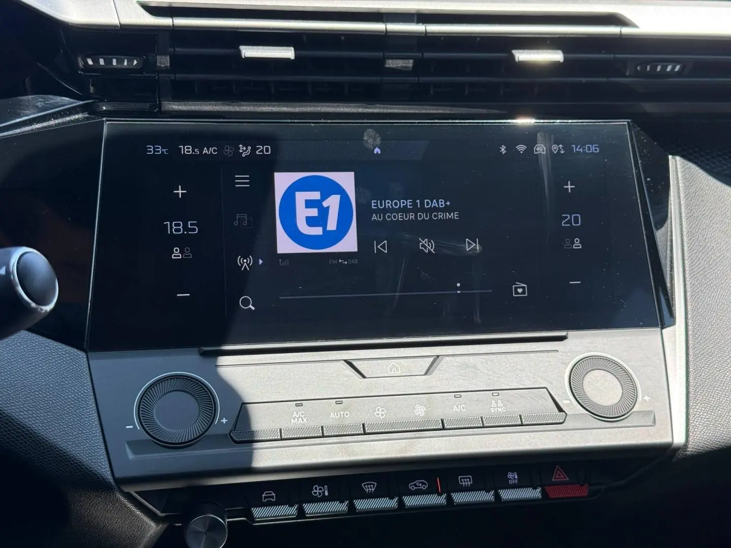 Vue rapprochée de l’écran tactile central et des commandes de climatisation d’une Peugeot 308 e-308 gris Artense.