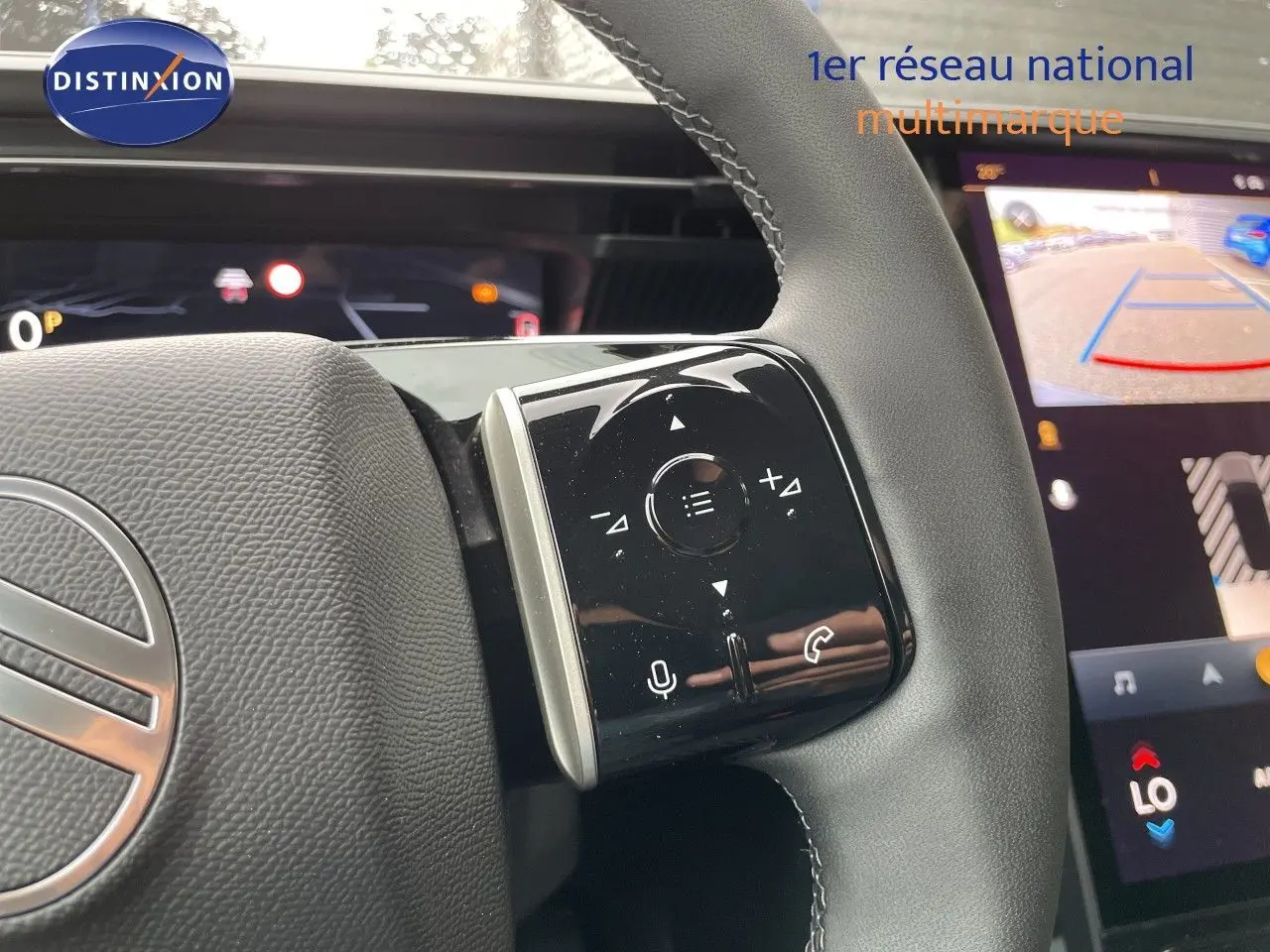 Gros plan sur le volant cuir noir de la Citroën C5 Aircross Hybrid 2026 avec commandes tactiles et écran multimédia en arrière-plan.