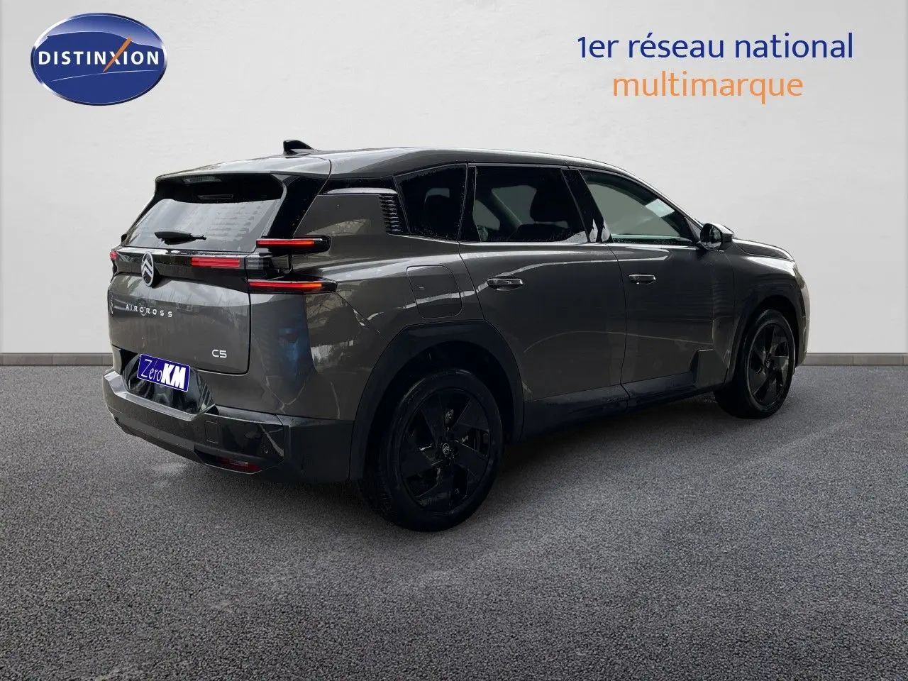 Vue 3/4 arrière droite d'un Citroën C5 Aircross Hybrid gris platinium métallisé avec jantes noires et toit noir.