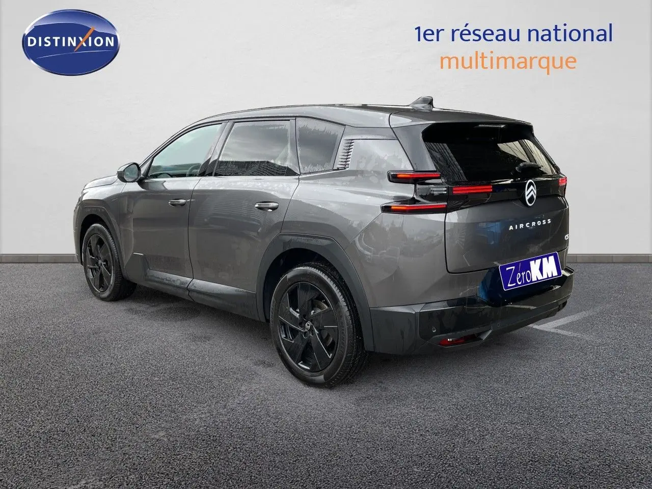 Vue 3/4 arrière droite d'un Citroën C5 Aircross Hybrid gris platinium métallisé avec jantes noires et feux arrière LED fins.