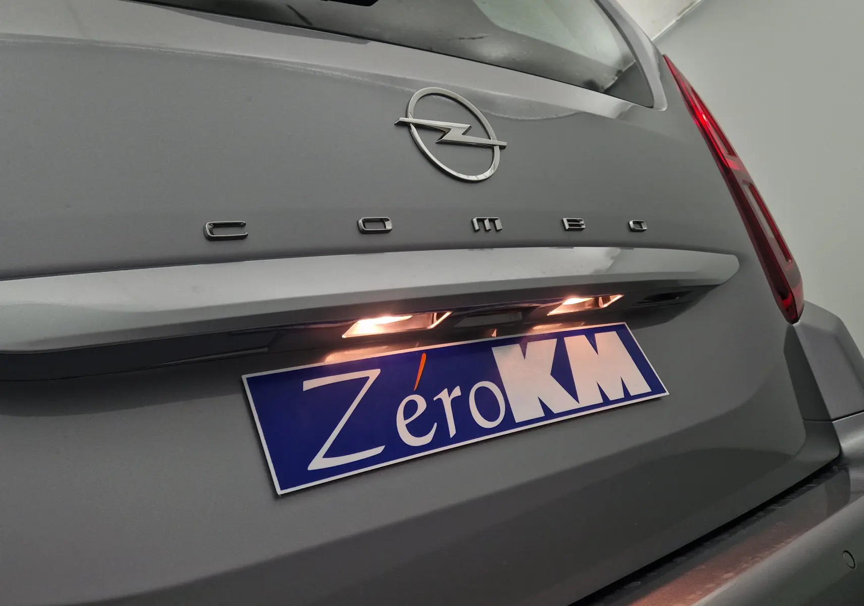 Gros plan sur l'arrière gris Artense d'un Opel Combo Life avec logo et plaque d'immatriculation éclairée Zero KM.