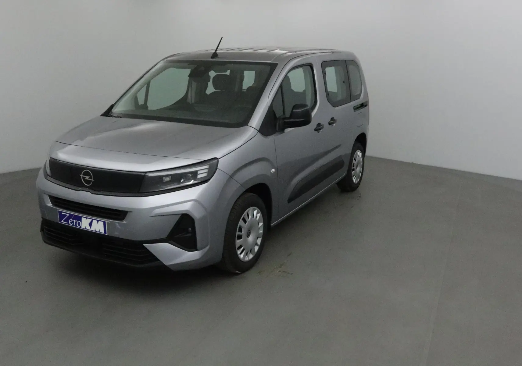 Vue 3/4 avant droit d'un Opel Combo Life gris Artense avec calandre noire et jantes acier dans un studio.