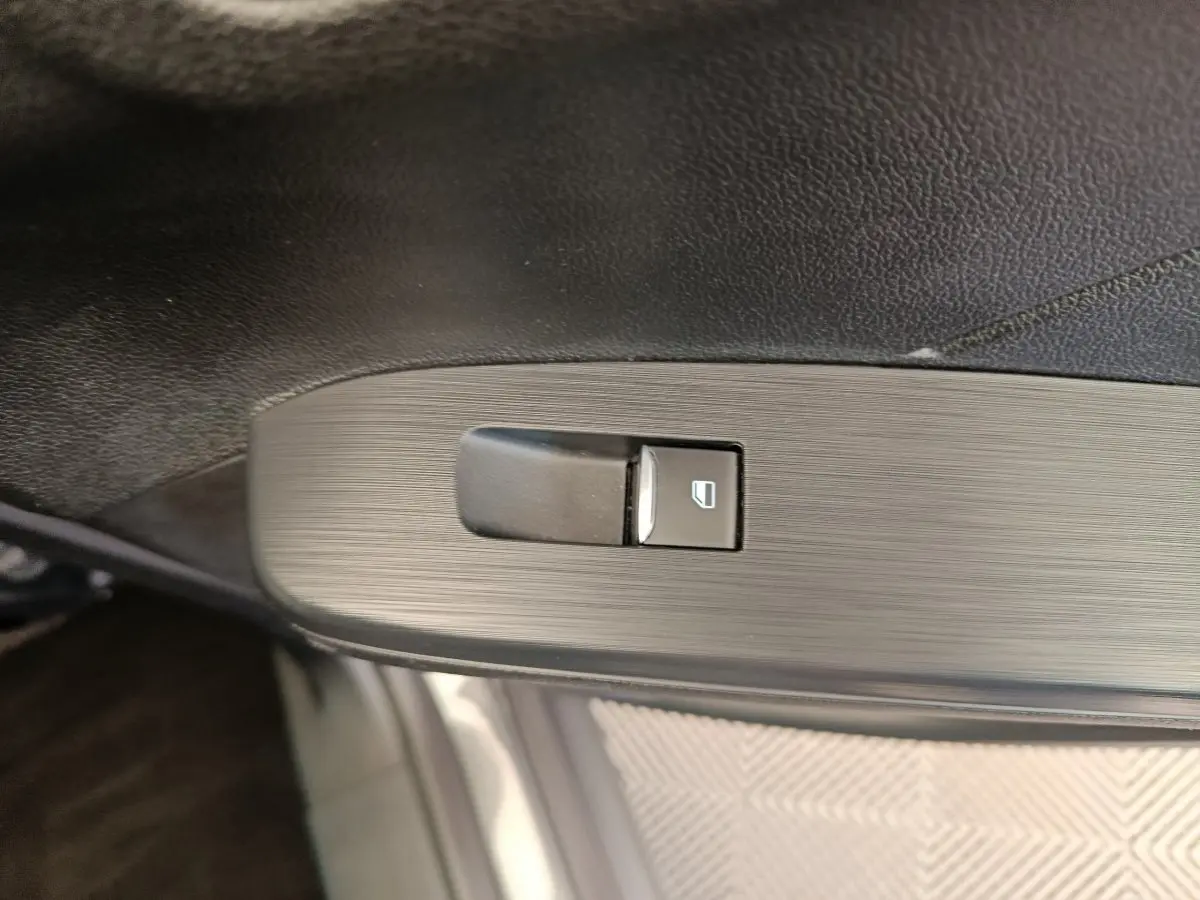 Gros plan sur le bouton de commande de lève-vitre côté conducteur du Ford Kuga gris clair 2024 St Line.