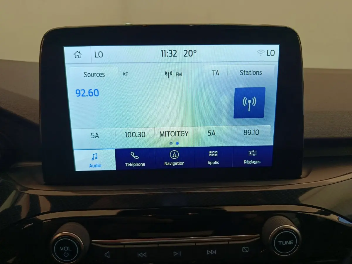 Écran tactile central du tableau de bord du Ford Kuga 2024 affichant la radio FM et les options multimédia.