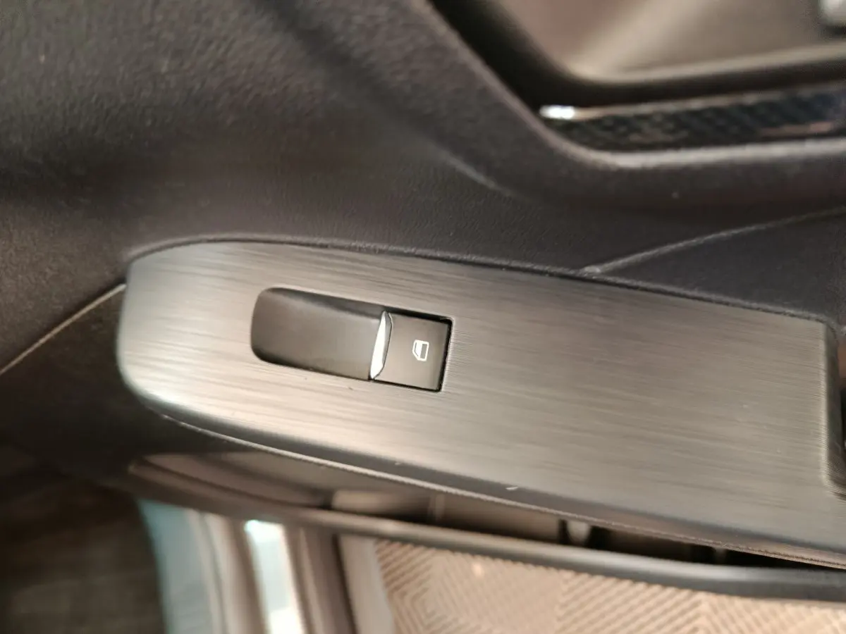 Bouton de commande de lève-vitre électrique sur la porte intérieure côté conducteur du Ford Kuga gris clair 2024 St Line.