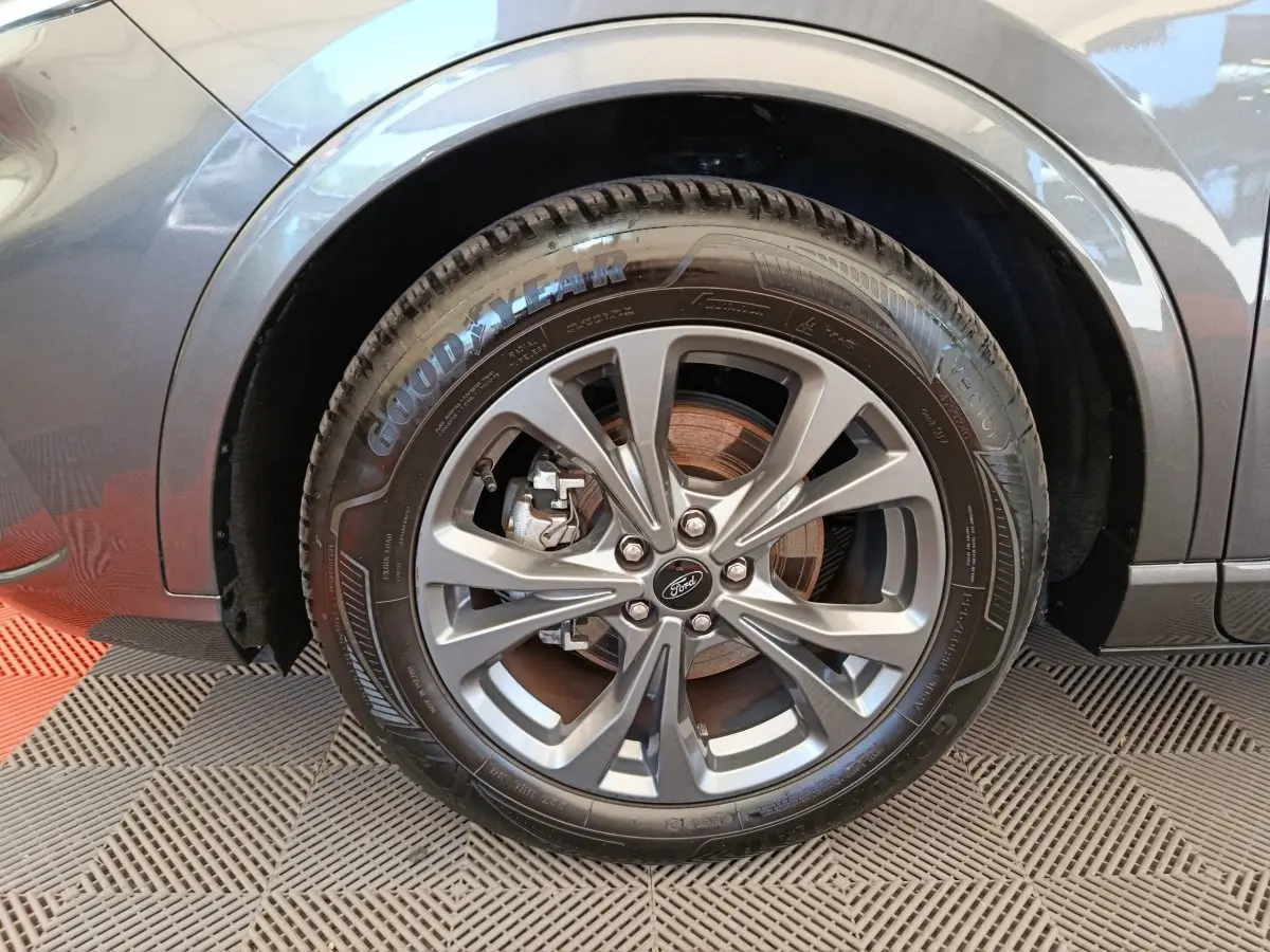 Gros plan sur la roue avant gauche gris clair du Ford Kuga 2024 avec jante alliage et pneu Goodyear.