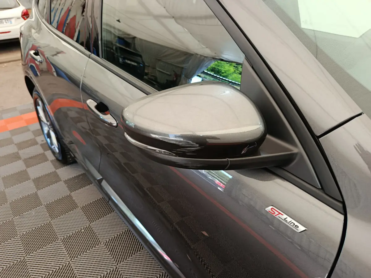 Vue rapprochée côté gauche du rétroviseur gris clair et de l'emblème ST Line sur une Ford Kuga 2024.