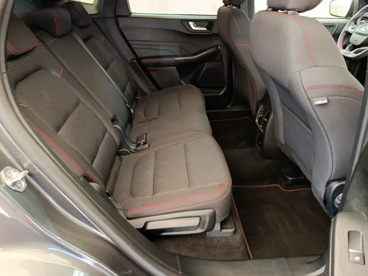 Vue côté gauche de la banquette arrière noire avec surpiqûres rouges du Ford Kuga 2024 finition St Line.