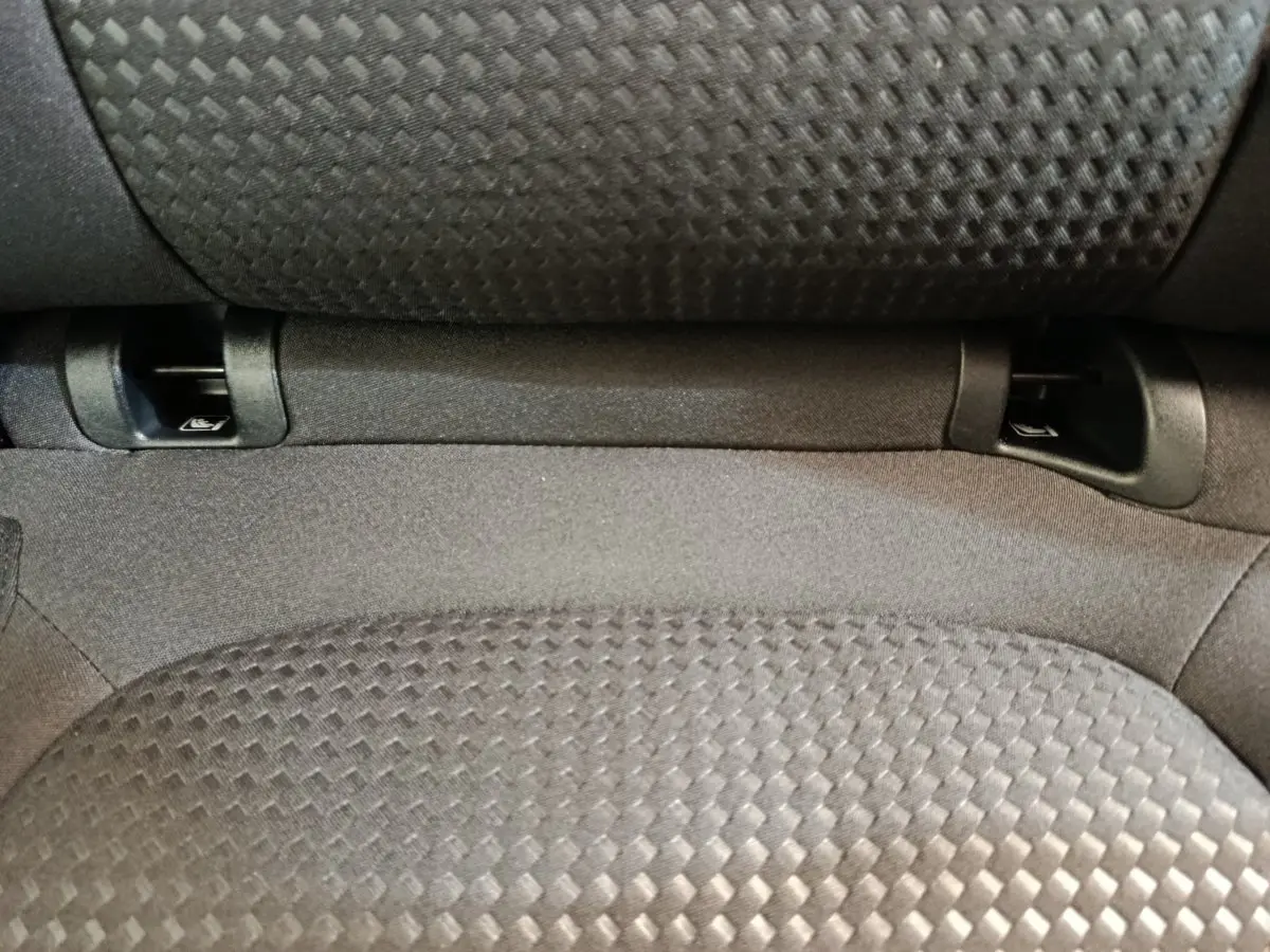 Gros plan sur l'assise arrière grise texturée du Ford Kuga 2024, montrant les fixations Isofix intégrées.