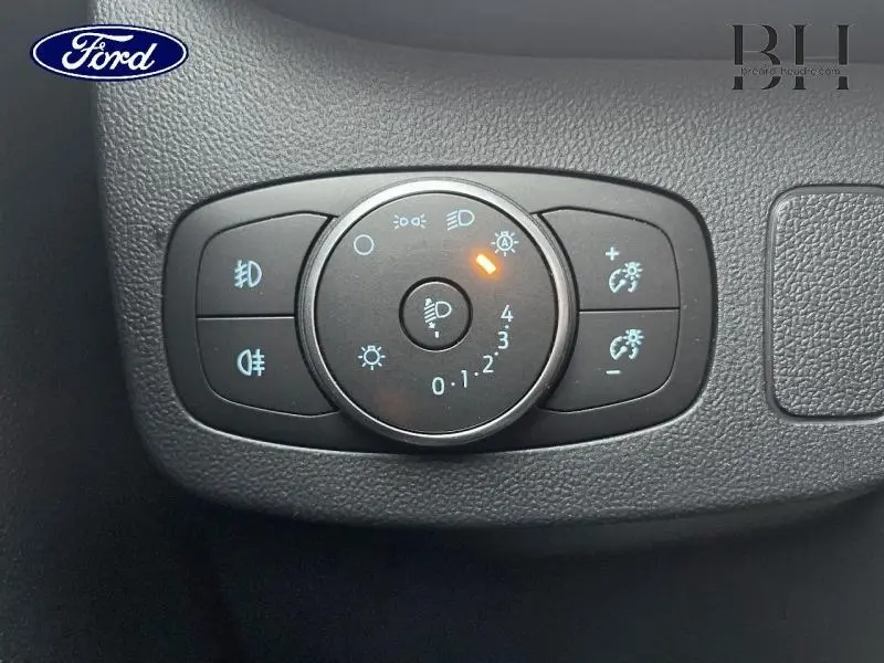 Gros plan sur le bouton de réglage des phares du Ford Puma 2023, montrant les commandes d’éclairage sur fond noir texturé.