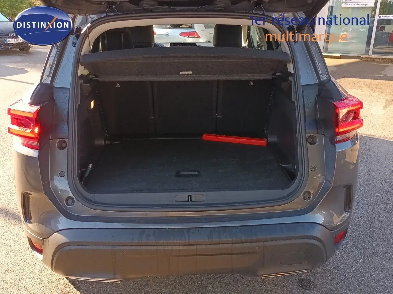 Vue arrière ouverte du Citroën C5 Aircross gris platinium métal, coffre spacieux avec cache-bagages déployé.