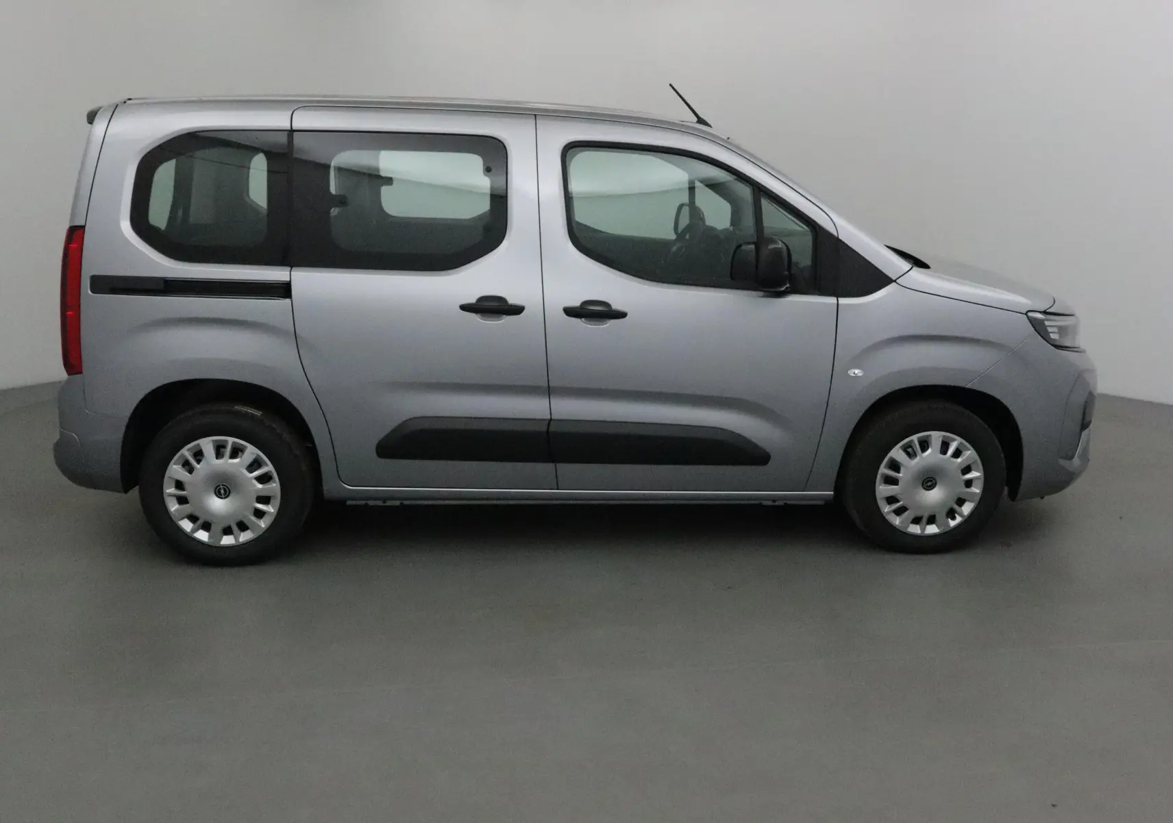 Profil côté gauche d'un Opel Combo Life gris Artense, montrant ses portes coulissantes et ses vitres teintées arrière.