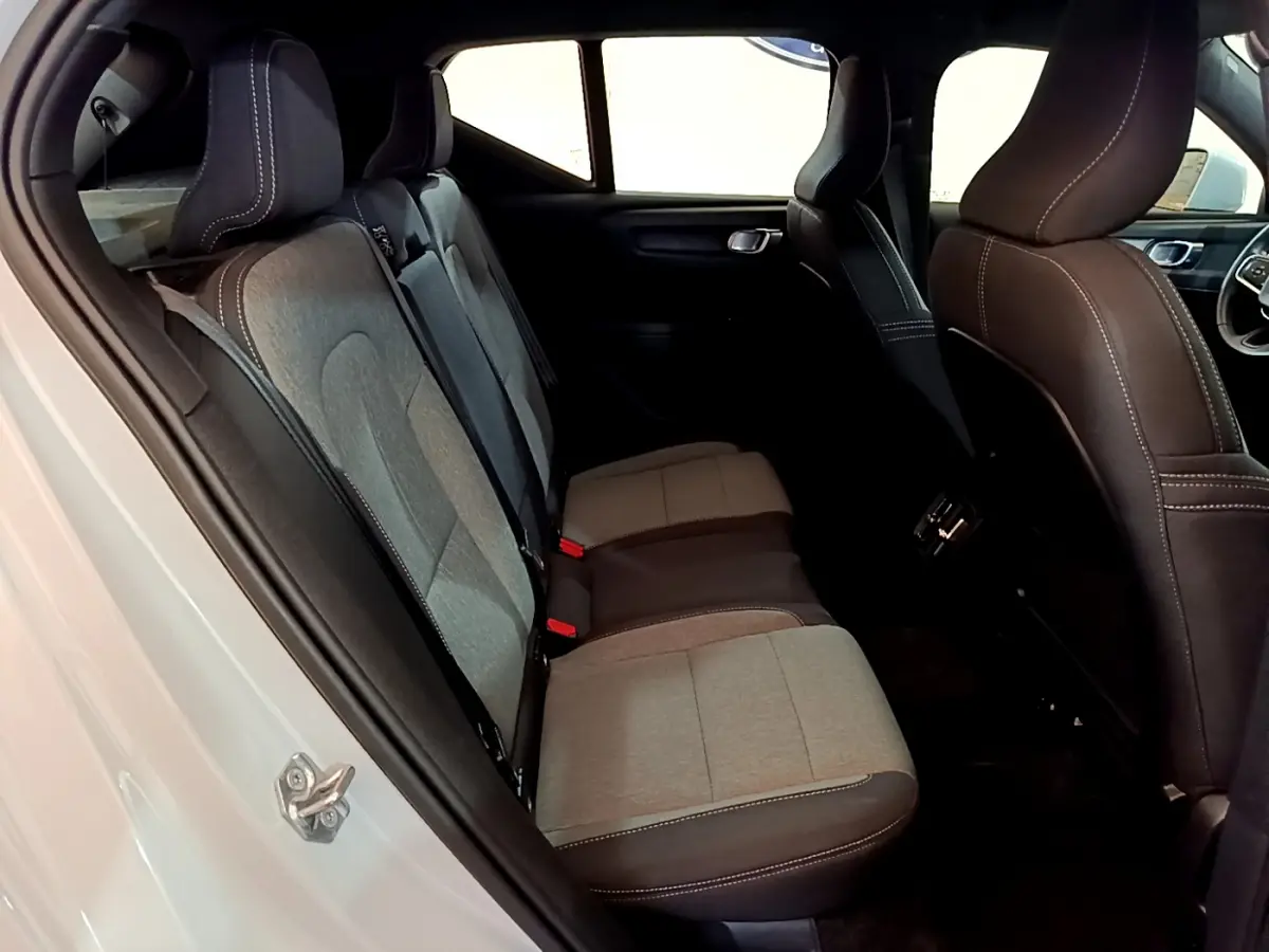 Vue côté gauche de l'habitacle arrière du Volvo XC40 T2 gris clair, montrant les sièges bicolores tissu et cuir.