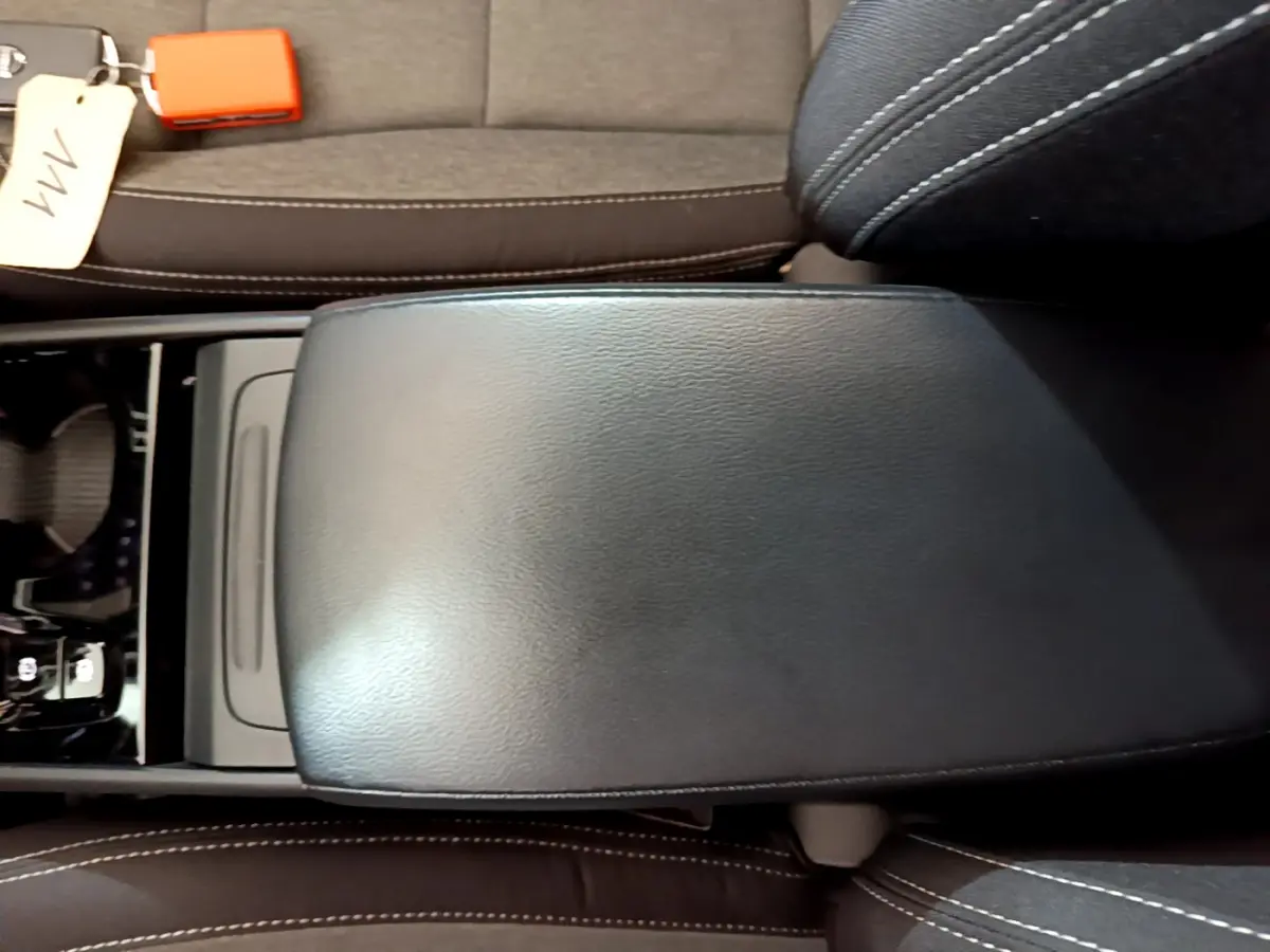 Vue rapprochée de l'accoudoir central en cuir noir et des sièges gris foncé du Volvo XC40 T2 Momentum 2020.