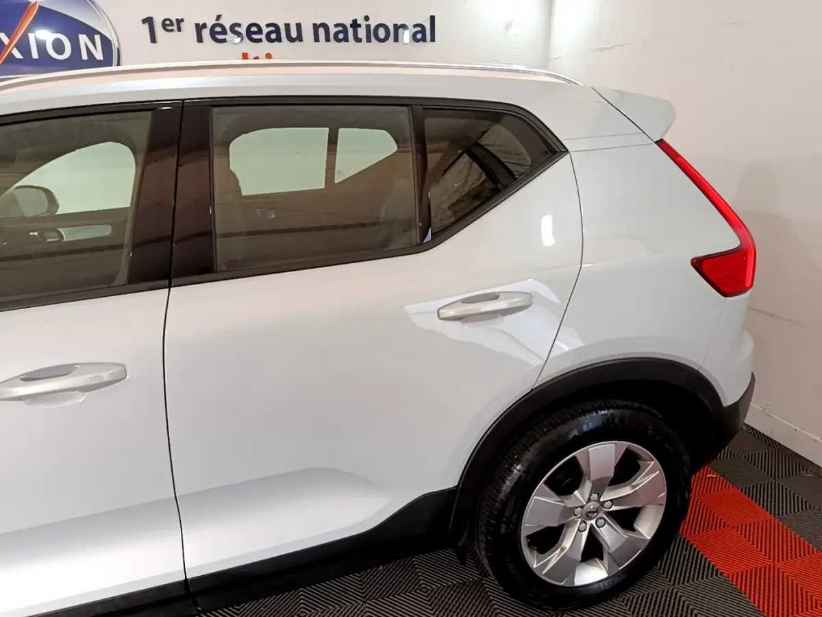 Vue côté droit arrière du Volvo XC40 T2 gris clair avec jante alliage et feux arrière LED distinctifs.