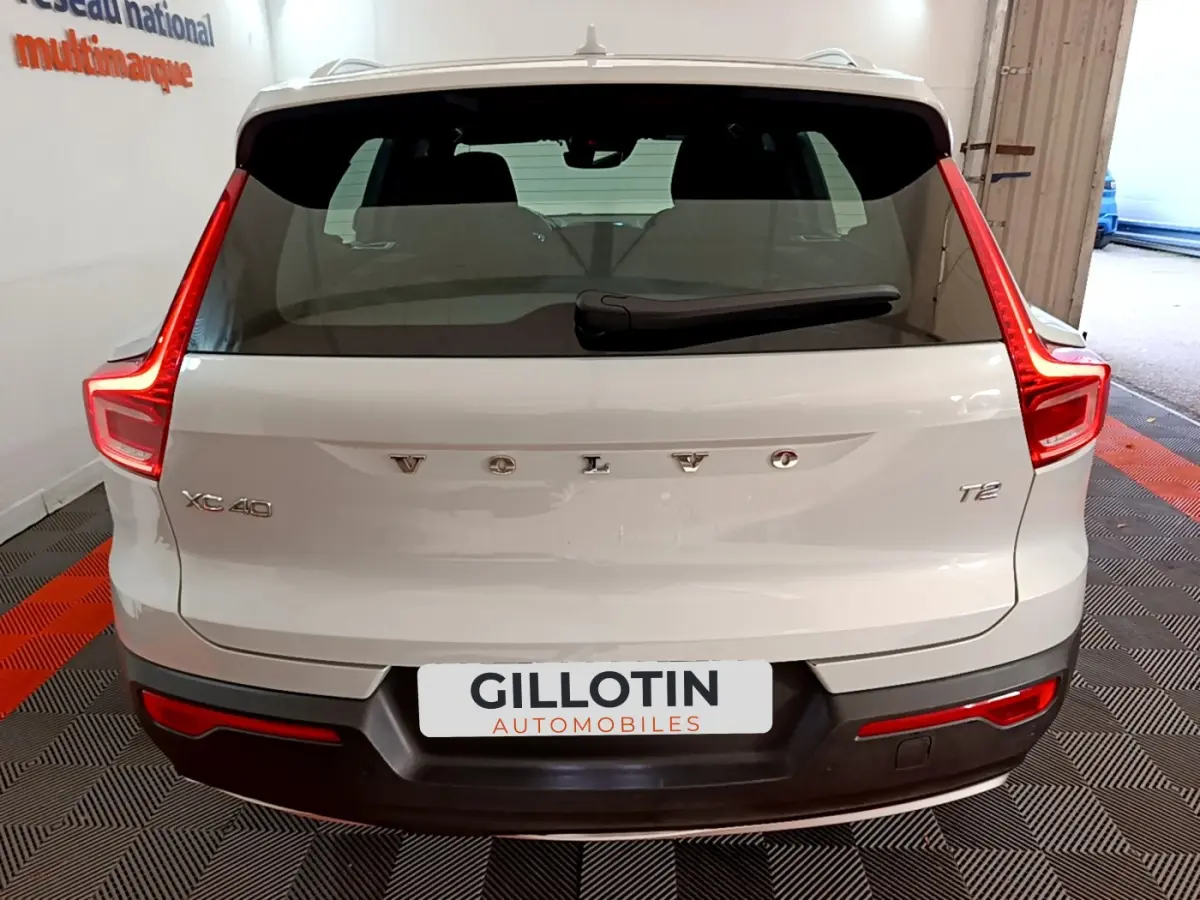 Vue arrière d'un Volvo XC40 T2 gris clair avec feux arrière LED et logo centré sur le hayon.