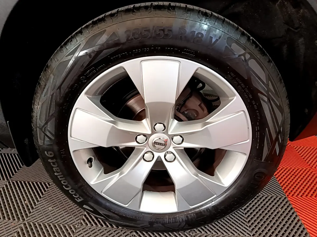 Gros plan sur la jante alliage argentée de 18 pouces du Volvo XC40 T2 Momentum gris clair, avec logo central visible.