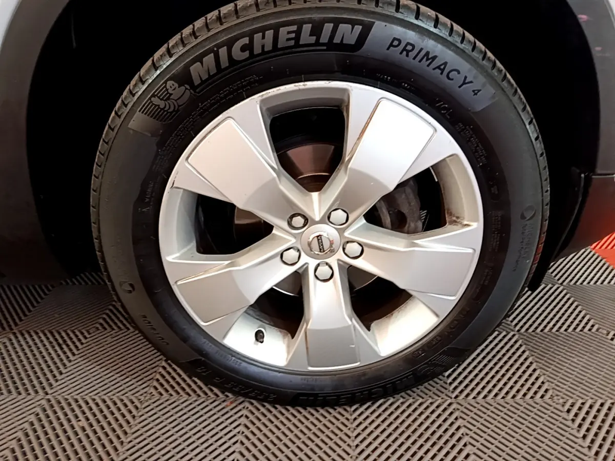 Gros plan sur la roue avant droite d'un Volvo XC40 gris clair, avec jante alliage et pneu Michelin Primacy 4.