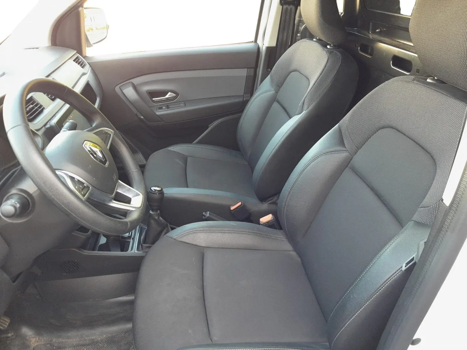 Vue intérieure côté conducteur du Renault Express Van 2023, sièges noirs et volant avec logo Renault visible.