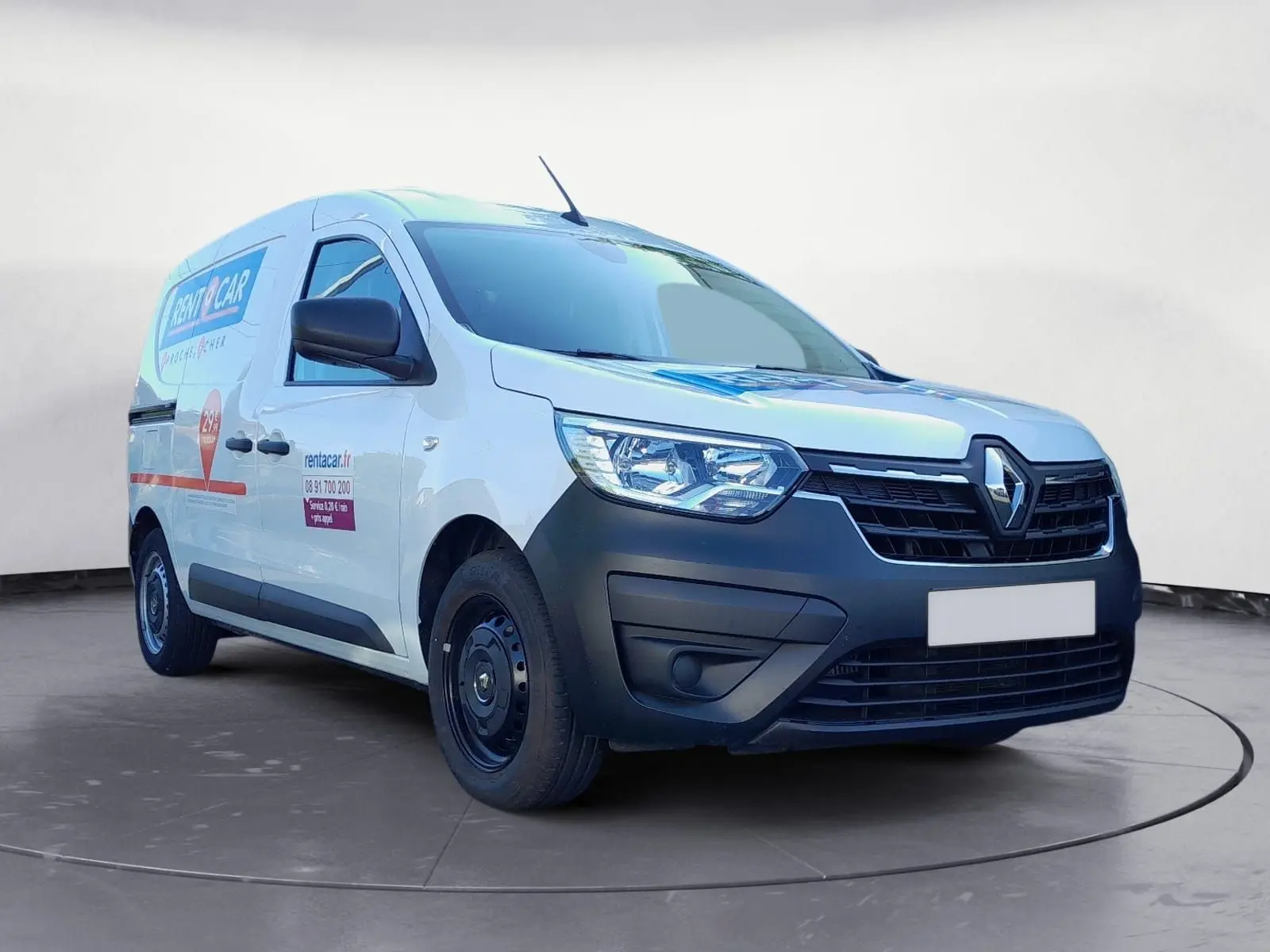 Vue 3/4 avant d’un Renault Express Van blanc de 2023 avec marquage publicitaire sur la porte latérale droite.