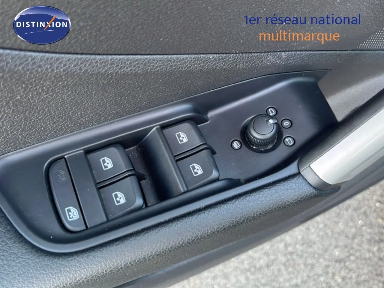 Gros plan sur les commandes des vitres et rétroviseurs côté conducteur d'une Audi Q2 noire, finition S-Line.