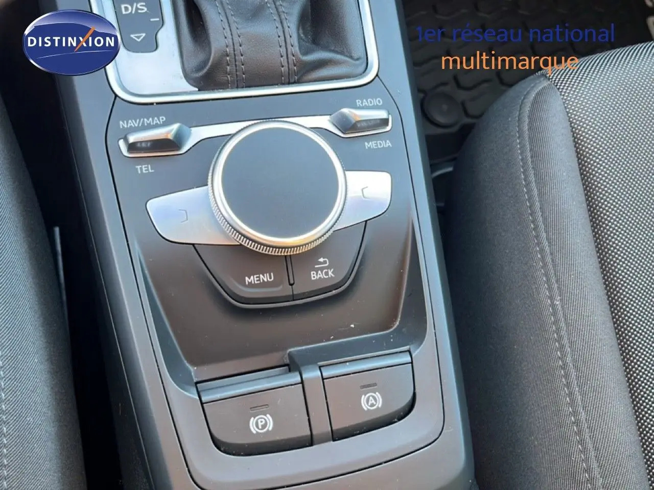 Console centrale avec commandes multimédia et frein à main électronique dans l'Audi Q2 noir mito metal 2023 vue de dessus.