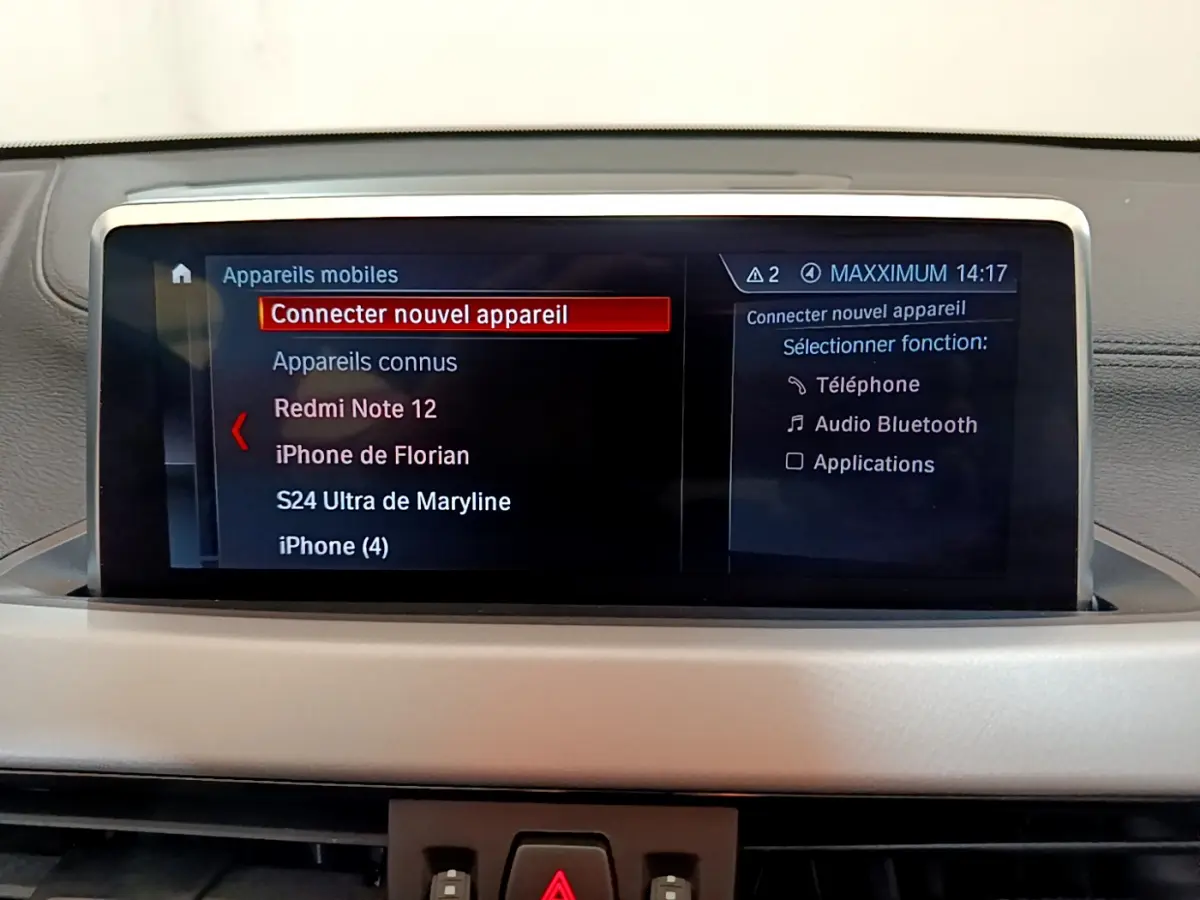 Écran central tactile de la BMW X2 blanc 2023 affichant le menu de connexion Bluetooth des appareils mobiles.