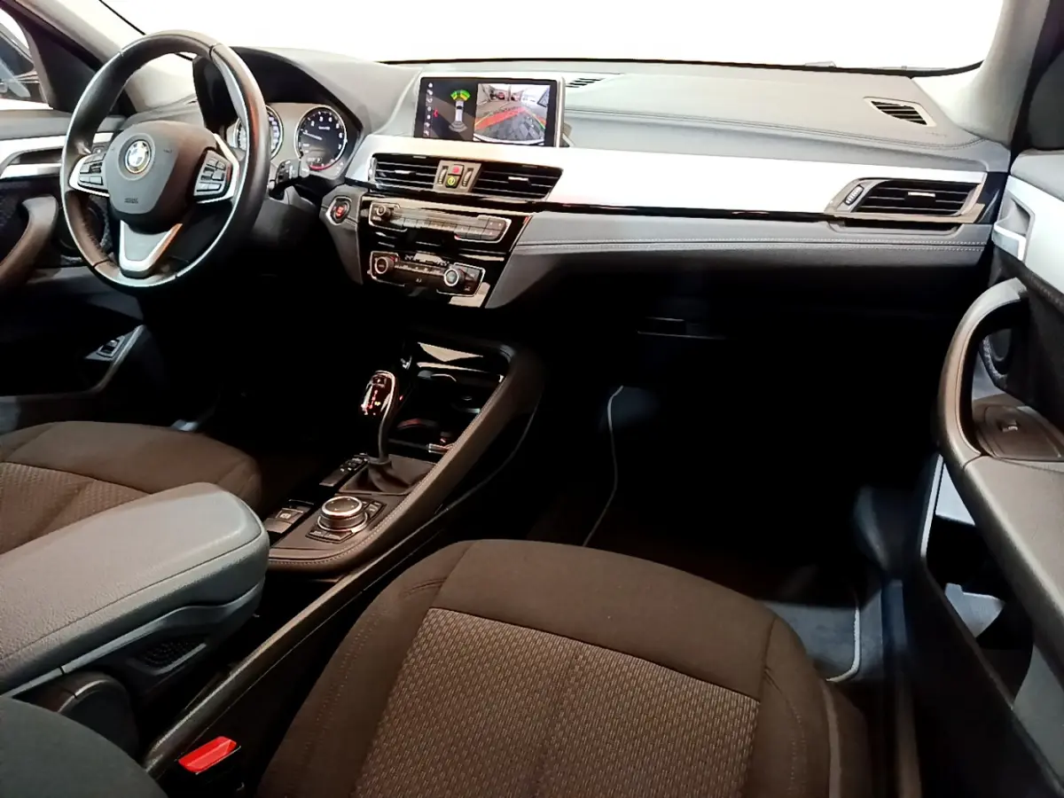 Intérieur avant droit de BMW X2 sDrive18i 2023, tableau de bord noir avec écran central affichant caméra de recul.