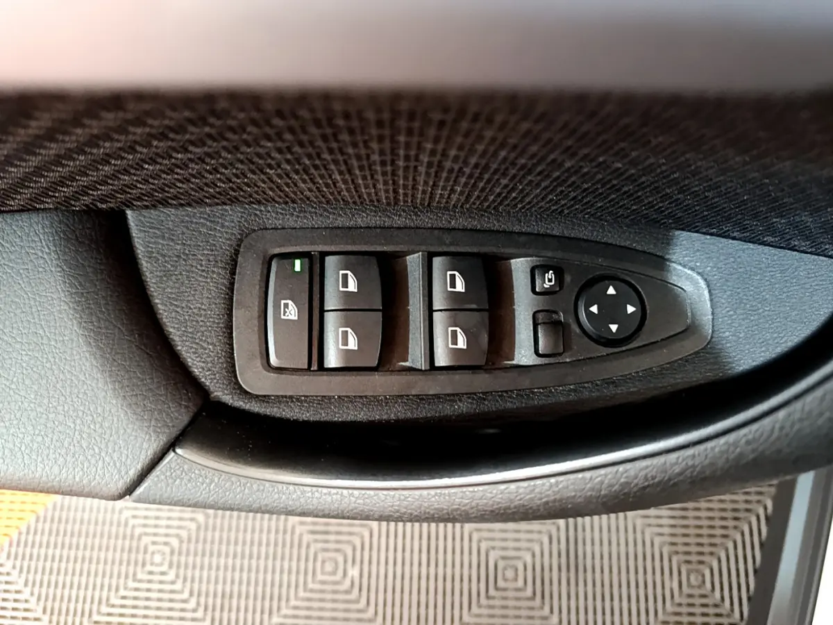 Panneau de commandes des vitres et rétroviseurs côté conducteur intérieur noir de BMW X2 blanc 2023.