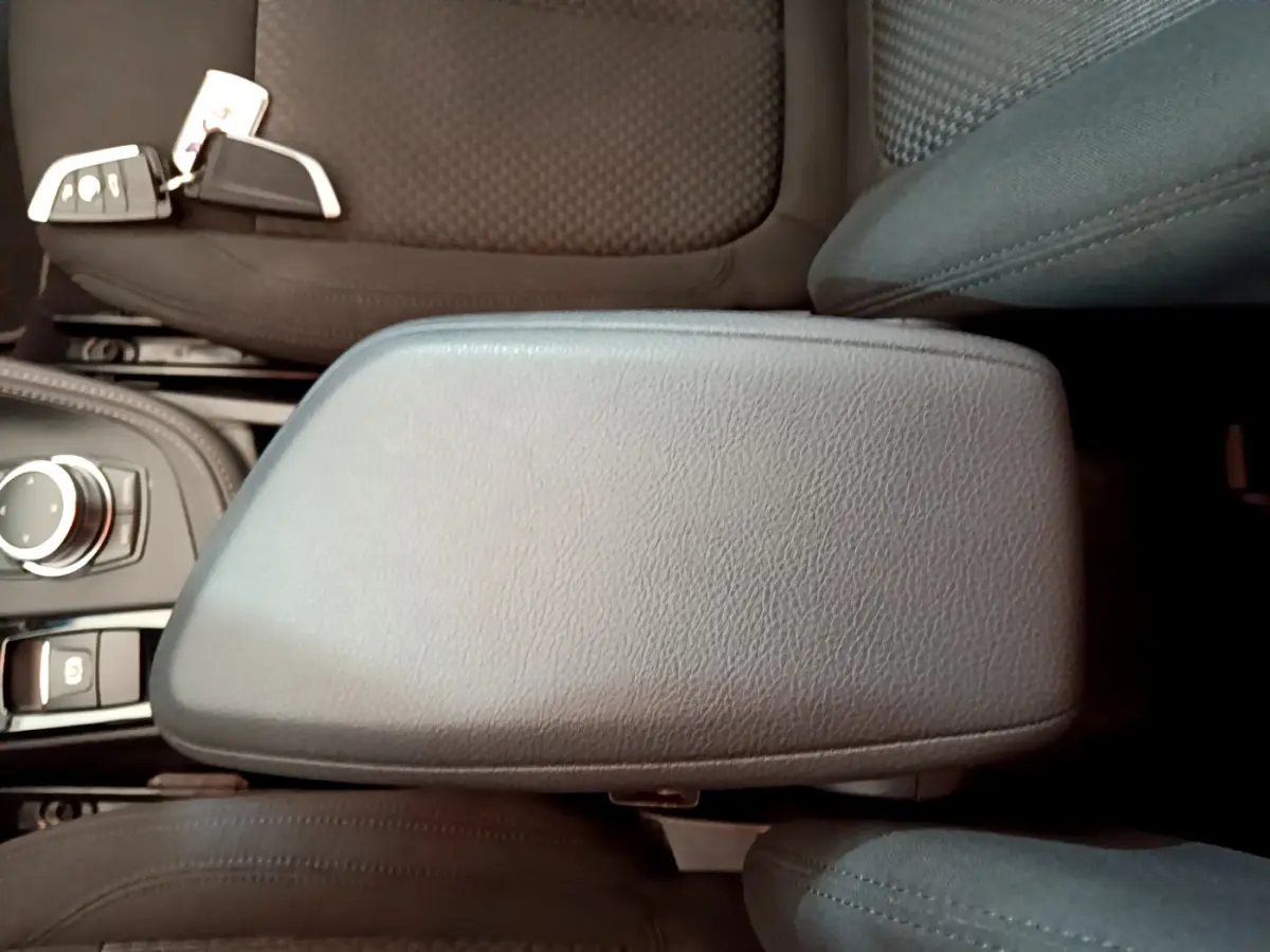 Accoudoir central en cuir noir avec molette de sélection et clé BMW sur siège tissu dans BMW X2 blanc 2023 sDrive18i