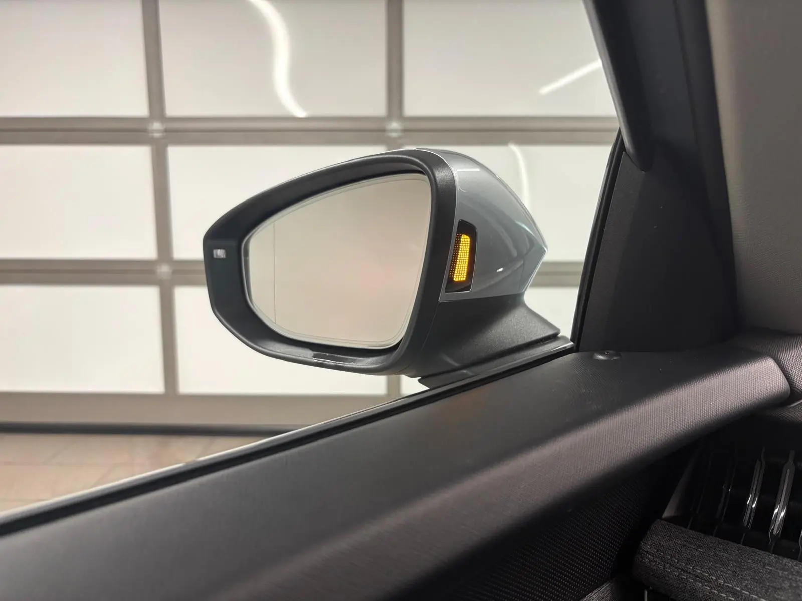 Rétroviseur extérieur côté gauche gris argent avec clignotant orange allumé sur Skoda Superb Combi 2025.