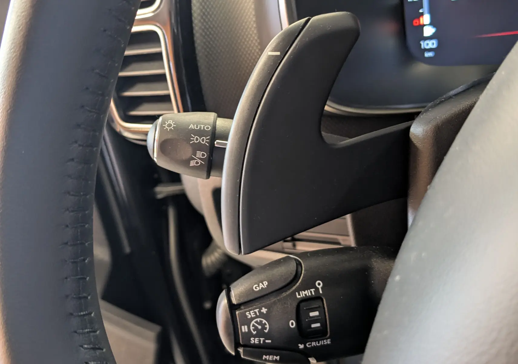 Gros plan sur les commandes au volant côté gauche d’un Citroën C5 Aircross noir, avec palettes de changement de vitesse et régulateur.