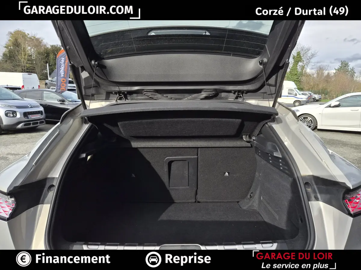 Coffre ouvert vu de l'arrière d'une DS4 2024 beige, montrant l'espace de rangement et la trappe à skis.