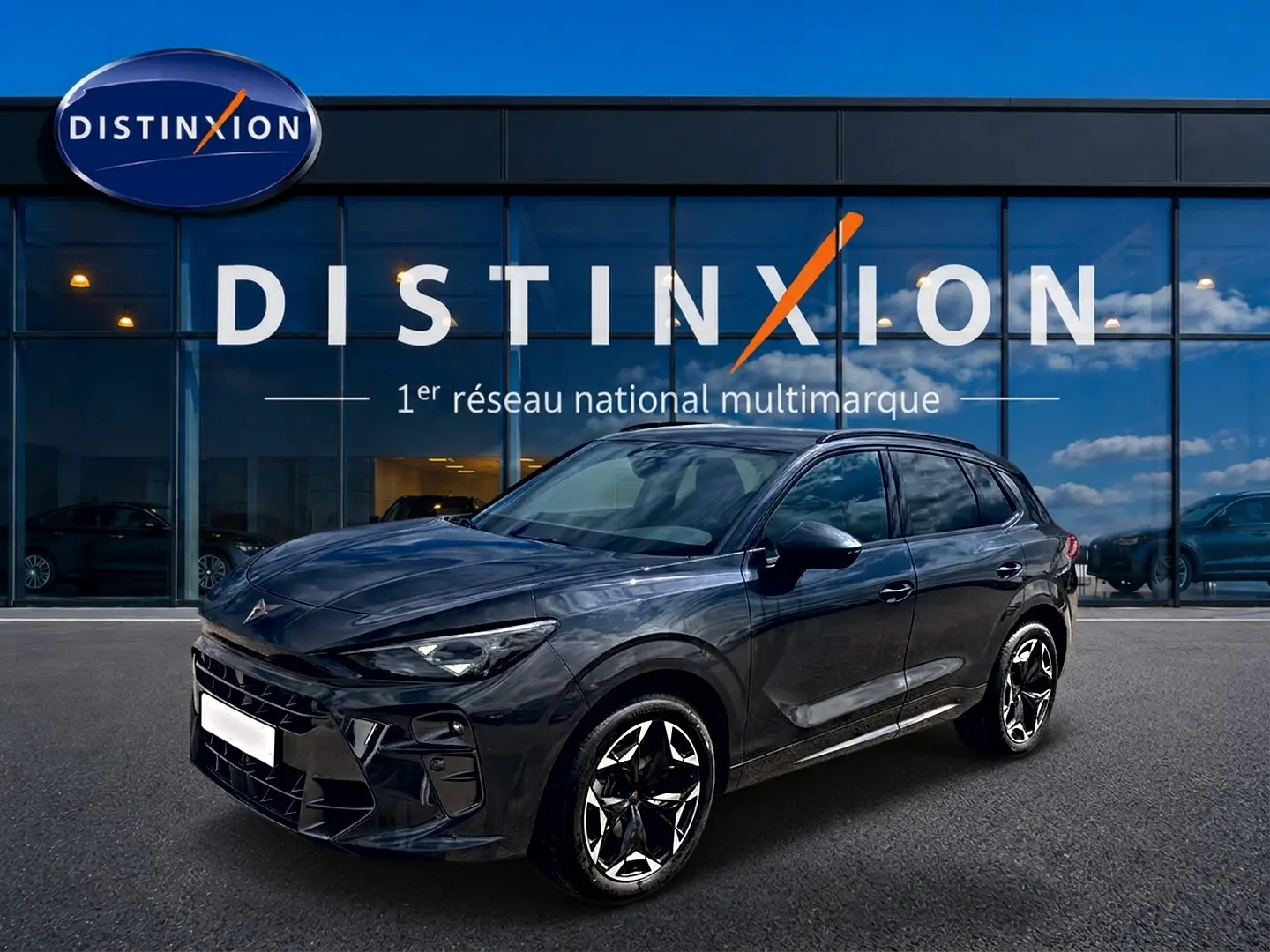 Vue 3/4 avant d'un CUPRA Terramar gris Timanfaya avec jantes alu noires et détails sportifs, devant une vitrine Distinxion.