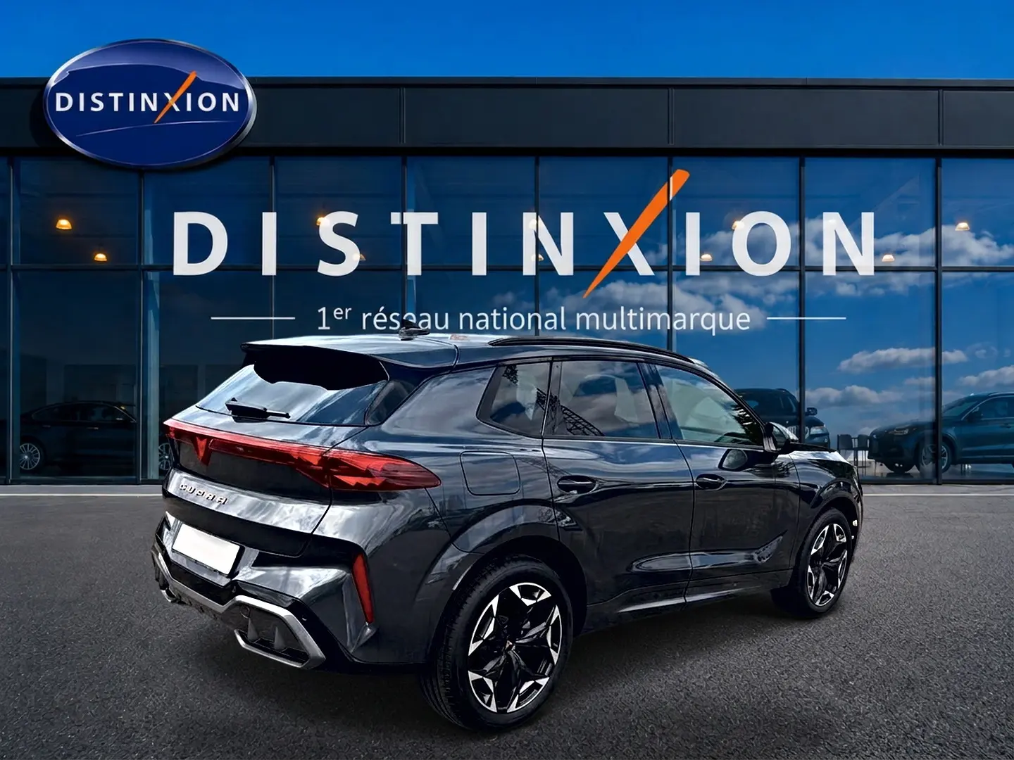 Vue 3/4 arrière droite d'un SUV CUPRA Terramar gris Timanfaya avec jantes 19 pouces et feux arrière LED allumés.